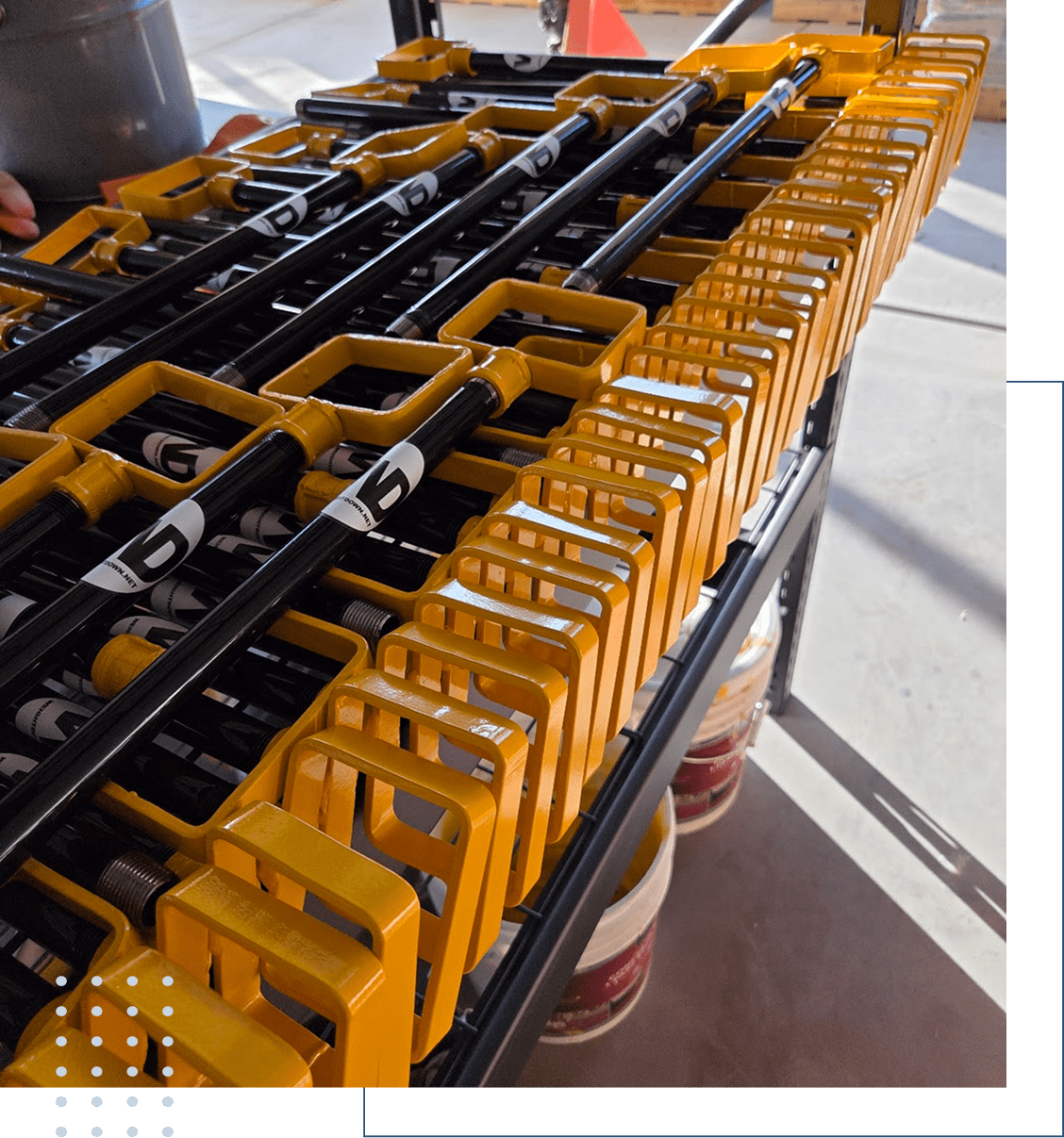 Industrial metal clamps and rods arranged on a rack in a workshop